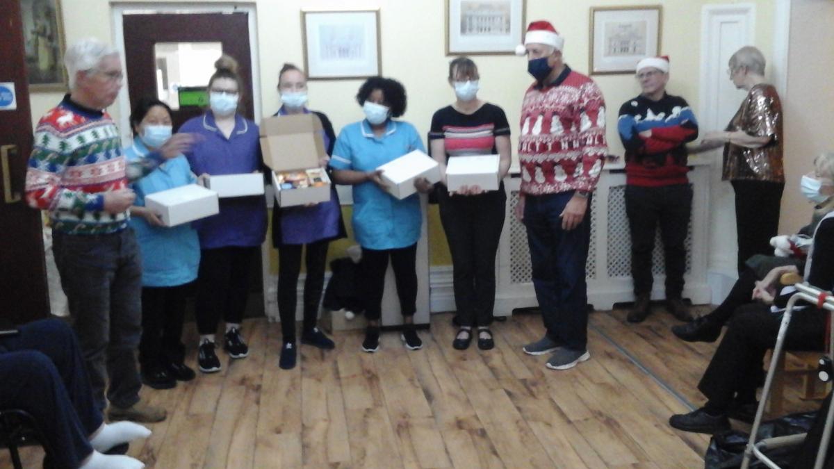 Rotary visit to Manor Court Residential Home - President David Lloyd presenting the Christmas boxes of food to the carers who had been unable to take afternoon tea with Nuneaton Rotary.