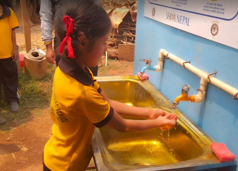 Nepal Project for clean water - The first pupil washes there hands in Brit Valley Rotary's clean uninfected water