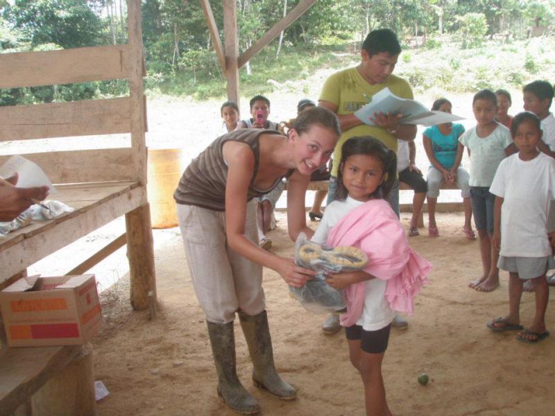 Cass Walker - Founder of  SelvaKids - Cass giving wellies to a girl in the Paltacocha community