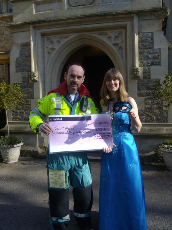 Swift Medics Cheque Presentation - Caroline in her ball gown with Jonathan in his Swift Medics jump suit