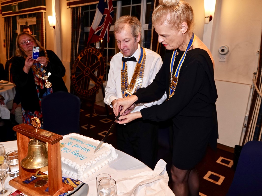Watford Rotary Club Celebrates 95 Years Of Service - Club President Tim Cox cutting the cake with Isabelle Baumann, Nancy's President