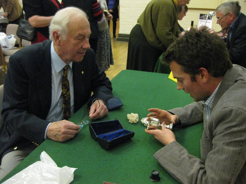 Antiques Roadshow - George Styles (right) examining an antique silver piece.