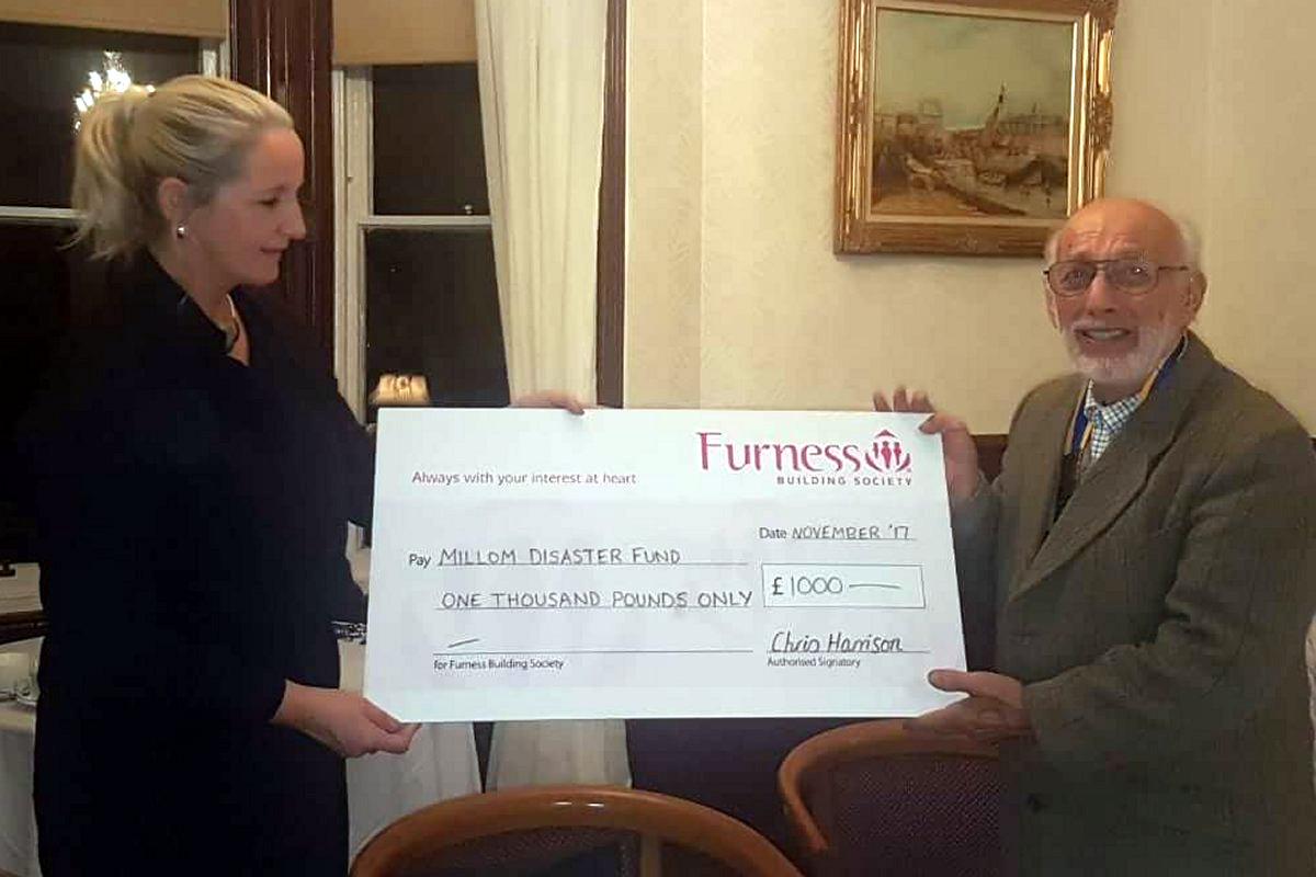 About Us - £1000 presented to Jenny Brumby by Rotary President Gil Scurrah for Millom's Flood Relief Fund