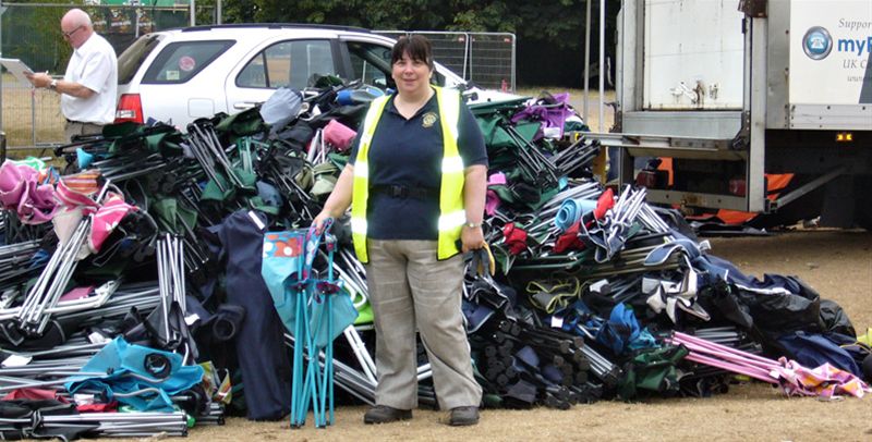 V Festival Tent Collection - Anita with a stack of chairs that have been collected