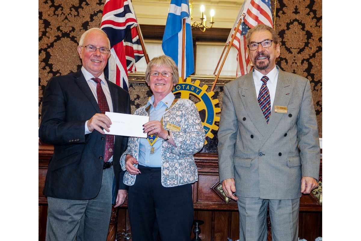 Annual Charity Disbursements - Cheque presentation to John MacLeod for Disaster Aid by President Ann and Rotarian Barclay
