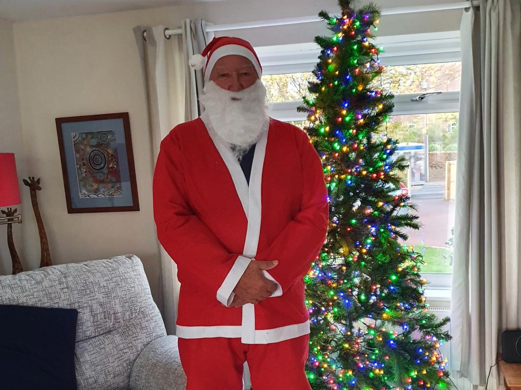 Young Carers at Christmas - Rotarian John Baker is getting into his Santa outfit before visiting the Young Carers