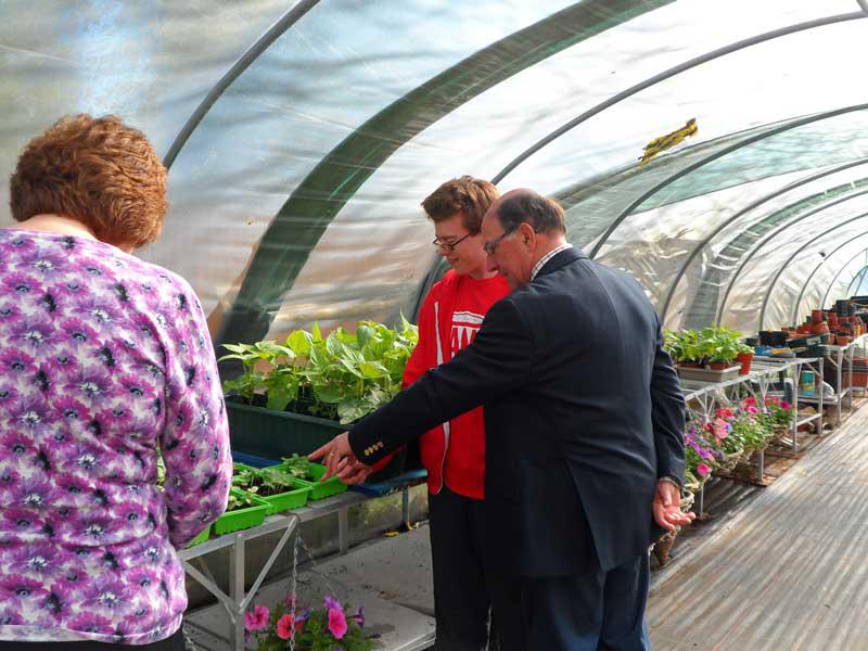 9 May 2014 - visit to Stony Dean School - Inside the polytunnel - student Adam shows President Roger the seedlings.