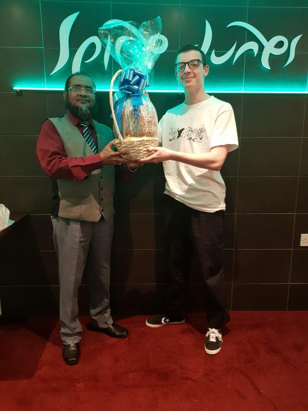Easter Egg Raffle 2019 - Photograph shows the winner, Lloyd presented with the egg by Mr Khlail Miah