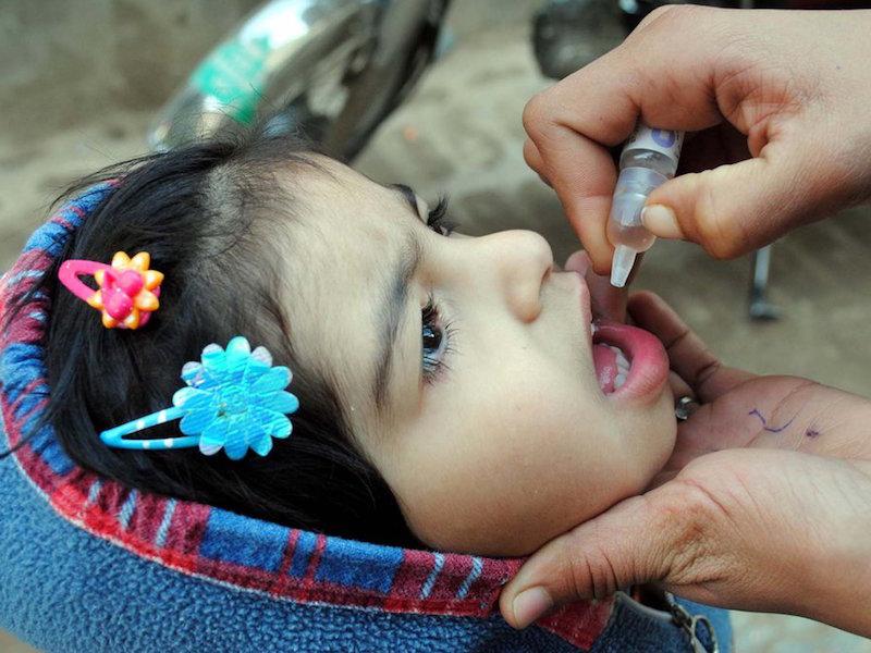 Eradicating Polio - Giving a child polio vaccine